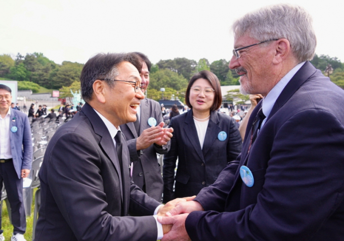 강기정 광주광역시장이 18일 오전 국립5·18민주묘지에서 열린 '제45주년 5·18민주화운동 기념식'에서 5·18민주화운동 당시 시민군으로 참여한 미국인 '데이비드 돌린저(한국명 임대운)'씨와 만나 인사를 나누고 있다./사진=광주시