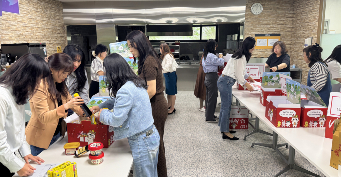 BNK경남은행 고객상담부 직원들이 독거노인 사랑잇기 어르신들에게 전달할 식료품 꾸러미를 직접 제작하고 있다./사진=BNK경남은행