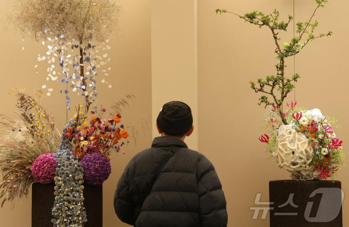 19일(현지시간) 영국 런던에서 열린 RHS 첼시 플라워쇼 프리뷰 행사에서 한 방문객이 꽃꽃이 디자인 출품작을 살펴보고 있다. ⓒ 로이터=뉴스1