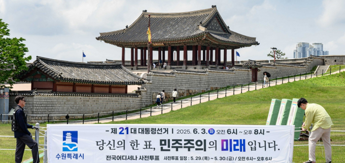 투표 참여를 독려하는 문구가 적힌 현수막을 설치는 모습. /사진제공=수원시