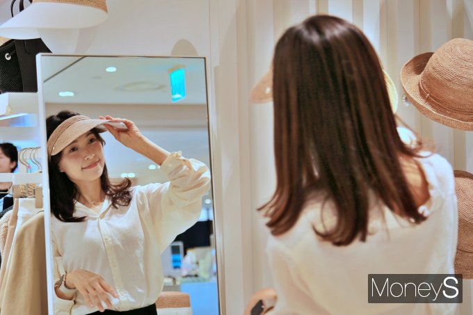 광주신세계 본관 3층 '헬렌카민스키' 매장에서 고객이 모자를 착용해보고 있다사진=광주신세계 제공.