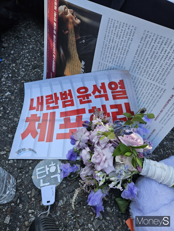 유지은씨는 국회에서 탄핵안 처리가 있던 지난해 12월14일 친구의 결혼식에 들러 부케를 받고 곧바로 집회에 참여해 한 손에는 부케를, 한 손에는 집회도구를 든채 시위를 벌였다. / 사진=유지은씨