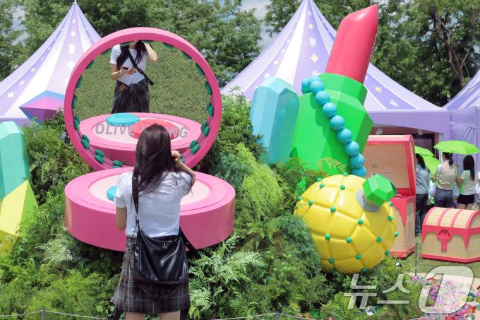 22일 서울 노들섬에서 열린 국내 최대 규모 체험형 뷰티&헬스 축제 '2025 올리브영 페스타'를 찾은 방문객이 대형 쿠션의 거울을 통해 아름다움을 점검하고 있다.2025.5.22/뉴스1 ⓒ News1 박정호 기자