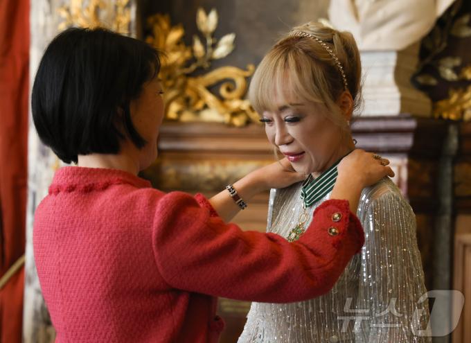 소프라노 조수미가 26일(현지시간) 프랑스 파리 오페라 코미크 극장(Op&eacute;ra Comique)에서 한국계 플뢰르 펠르렝 전 프랑스 문화부 장관에게 프랑스 문화예술공로훈장 최고 등급인 코망되르(Commandeur)를 수여받고 있다. 2025.5.26/뉴스1 ⓒ News1 이준성 기자