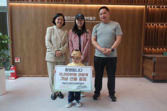 국립조선왕조실록박물관 1만 번째 관람객인 정구빈 어린이와 가족, 실록박물관장(맨 왼쪽)(국가유산청 제공)