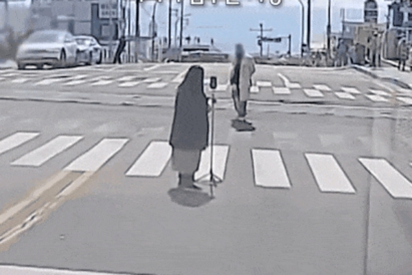 도로 한복판에서 차량 주행을 막고 인생샷을 건지려는 민폐 관광객 모습이 공개됐다. 사진은 부산 해운대구 청사포 해변 인근 도로 한복판에서 사진을 찍는 커플 모습. /사진=보배드림 캡처
