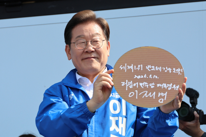 이재명 더불어민주당 대통령 후보가 지난달 12일 오후 경기 화성시 동탄 센트럴파크 음악분수중앙광장에서 '세계1위! 반도체 강국도약!'이라고 쓴 반도체 웨이퍼를 들어 보이고 있다. /사진=공동취재(뉴스1)