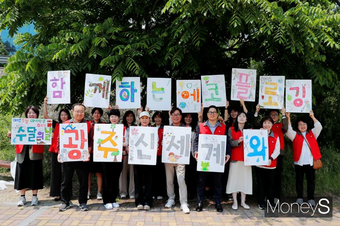 광주신세계 임직원들이 지난 5월 수달의 날을 맞아 광주천변 일대에서 플로깅 및 수달 서식지 관찰을 마친 후 기념사진을 찍고 있다/사진=광주신세계 제공.