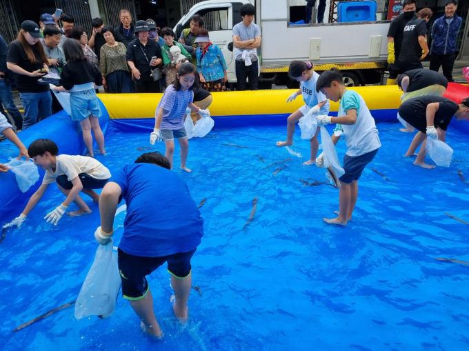 제8회 영궁축원제에서 어린이들이 붕장어를 잡고 있는 모습./사진=사천시