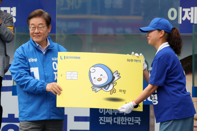 이재명 대통령은 지난달 20일 대선 후보 시절 경기 파주시 금릉역 중앙광장에서 열린 유세에서 선거운동원으로부터 경기지역화폐 파주페이 모형을 받으며, 자신의 대선공약을 시민들에게 피력했다. /사진=뉴스1