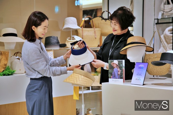 광주신세계 본관 3층 '에릭자비츠' 매장에서 직원이 고객에게 모자를 설명하고 있다/사진=광주신세계 제공.
