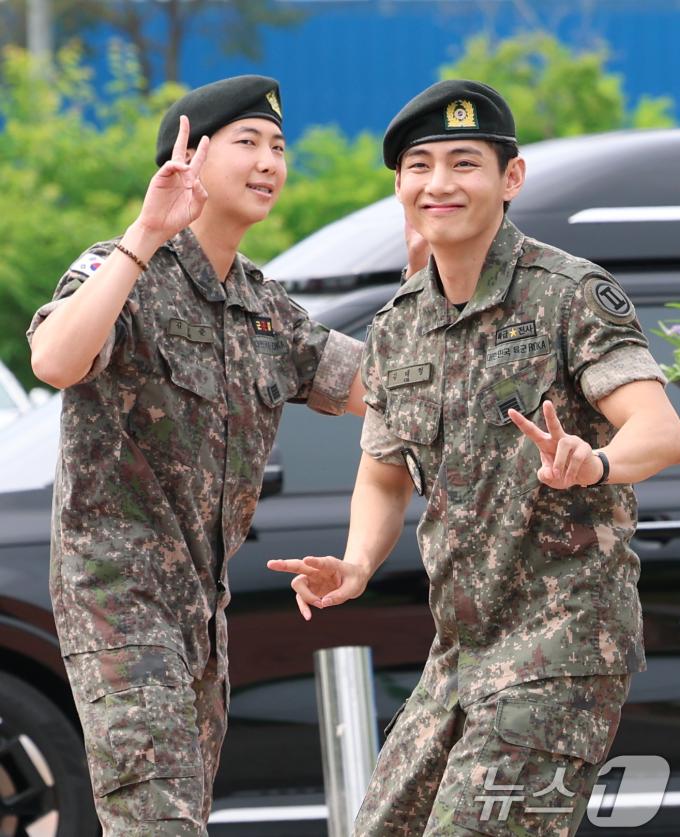 방탄소년단(BTS)의 RM(김남준, 30)과 뷔(김태형, 29)가 10일 오전 강원도 춘천시 신북읍 체육공원 축구장에서 군 복무를 마친 뒤 전역 인사를 하고 있다. ⓒ News1 권현진 기자