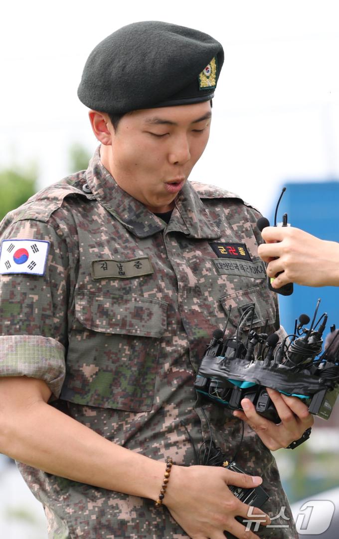 방탄소년단(BTS)의 RM(왼쪽)이 10일 오전 강원도 춘천시 신북읍 체육공원 축구장에서 인터뷰를 마친 뒤 마이크를 떨어뜨리고 있다. ⓒ News1 권현진 기자