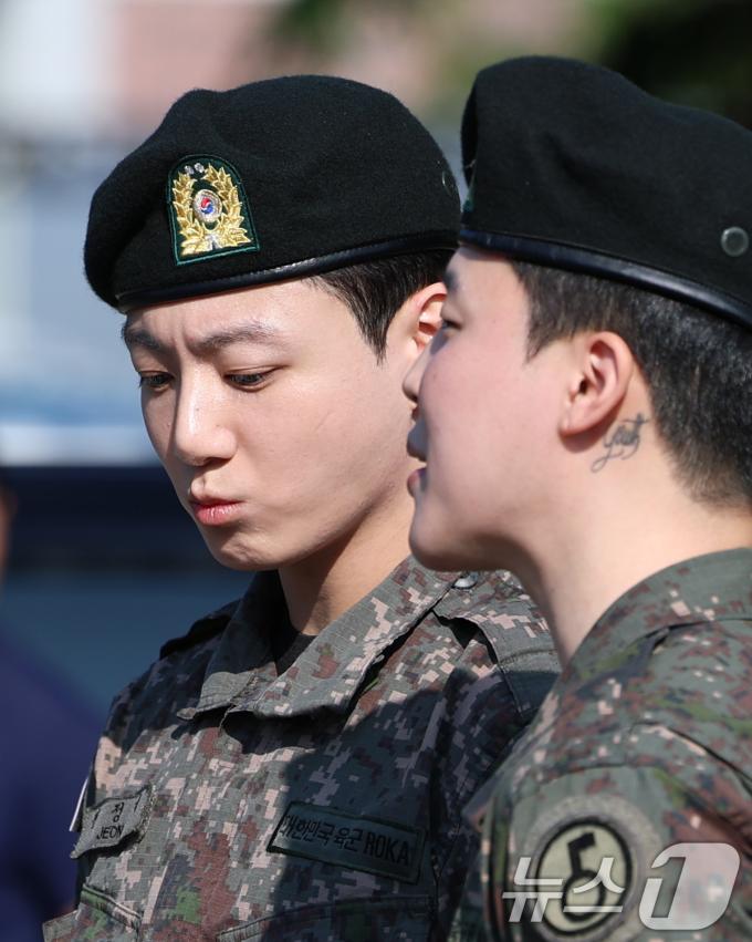 방탄소년단(BTS)의 정국과 지민(오른쪽)이 11일 오전 경기도 연천군 연천공설운동장에서 군 복무를 마친 뒤 군복무를 마친 뒤 전역 인사를 전하고 있다. ⓒ News1 권현진 기자