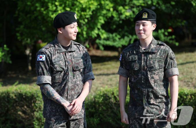 방탄소년단(BTS)의 정국과 지민(오른쪽)이 11일 오전 경기도 연천군 연천공설운동장에서 군 복무를 마친 뒤 군복무를 마친 뒤 수줍은 미소를 짓고 있다. ⓒ News1 권현진 기자