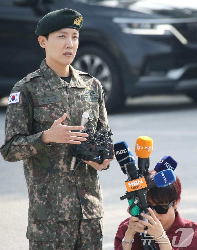 방탄소년단(BTS) 진(오른쪽)이 17일 강원도 원주시에 위치한 육군 제36보병사단 백호 신병교육대에서 전역 인사를 하는 제이홉의 인터뷰를 위해 마이크를 들어주고 있다. 2024.10.17./뉴스1 ⓒ News1 권현진 기자