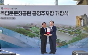 우오현(오른쪽) SM그룹 회장이 지난 12일 서울 서대문구 독립문문화공원 공영주차장에서 열린 개장식에서 이성헌 서대문구청장으로부터 감사패를 받았다. /사진=SM그룹