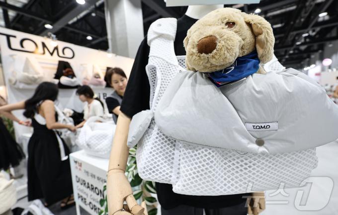 13일 서울 강서구 코엑스 마곡에서 열린 '2025 케이펫페어'에서 관람객들이 반려동물 포대기를 살펴보고 있다. 2025.6.13/뉴스1 ⓒ News1 김도우 기자