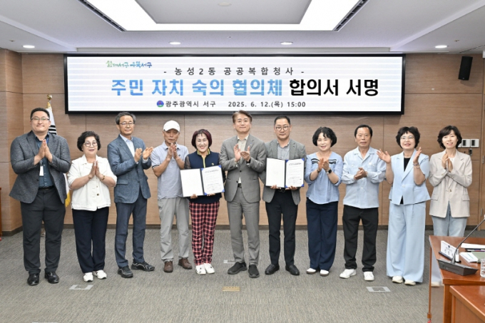 김이강 광주시 서구청장(왼쪽 여섯번째)이 12일 서구청 나눔홀에서 농성2동 공공복합청사 주민자치 숙의 협의체 합의서 서명 후 참석자들과 기념촬영을 하고 있다./광주 서구청 