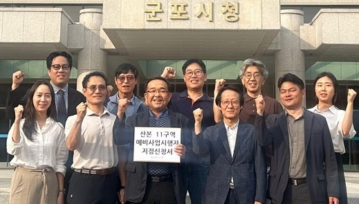 11구역 예비사업시행자 신청서를 들고 기념촬영하는 주민대표단.  /사진제공=군포시