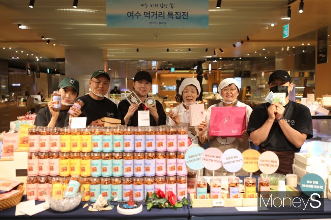 롯데백화점 광주점 지하1층 행사장에서 마련한 '여수 먹거리 특접전' 참여 업체 관계자들이 자사 제품을 들고 기념촬영을 하고 있다/사진=롯데백화점 홍보 3팀 제공.