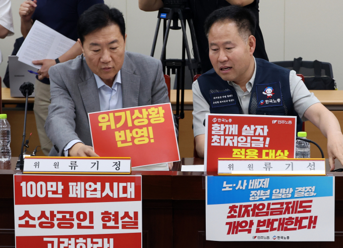 지난 10일 세종시 정부세종청사에서 열린 최저임금위원회 4차 전원회의에 앞서 류기정 사용자 위원과 정문주 근로자 위원이 각자의 주장이 담긴 팻말을 자리에 배치하고 있다. / 사진=뉴시스 강종민 기자  