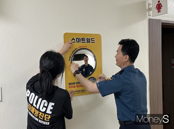 광주 남부경찰서 경찰관들이 광주대학교 강의동인 호심관 여성 화장실 입구에 안심거을을 설치하고 있다/사진=광주대학교 제공.