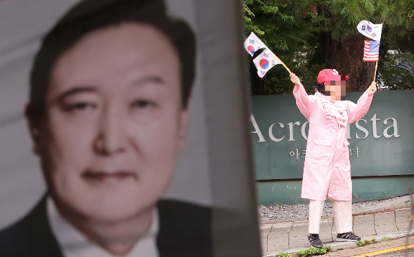 윤석열 전 대통령 체포영장 기각 소식에 지지자들이 크게 환호했다. 사진은 서울 서초구 아크로비스타 윤석열 전 대통령 사저 앞에서 한 지지자가 태극기를 흔들고 있는 모습. /사진=뉴스1