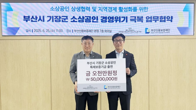 진종관 부산신보 보증지원본부장과 서찬우 신세계사이먼 부산점장(오른쪽)이 업무협약을 체결하고 기념촬영을 하고 있다./사진=신세계사이먼