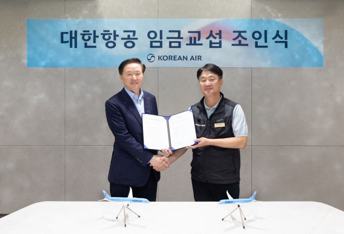 우기홍(왼쪽) 대한항공 부회장과 조영남 대한항공 노동조합위원장이 26일 서울 강서구 대한항공 본사에서 열린 '2025년 임금교섭 조인식'을 통해 올해 임금협상을 마무리 지었다. /사진=대한항공 