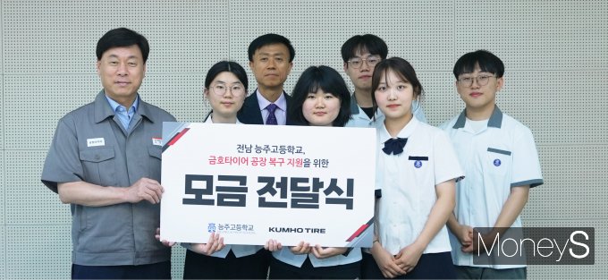 김명선 금호타이어 생산기술총괄 부사장(왼쪽)과 성태모 능주고등학교 교장, 학생들이 함께  광주공장 피해 복구를 위한 성금을 전달한 후 기념 사진 촬영을 하고 있다/사진=금호타이어 제공.