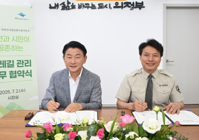 김동근 의정부시장(왼쪽)이 2일 시장실에서 북한산국립공원 도봉사무소 이진범 소장과 '자연과 시민이 공존하는 둘레길 관리' 업무협약을 맺고 기념촬영을 하고  있다. /사진제공=의정부시