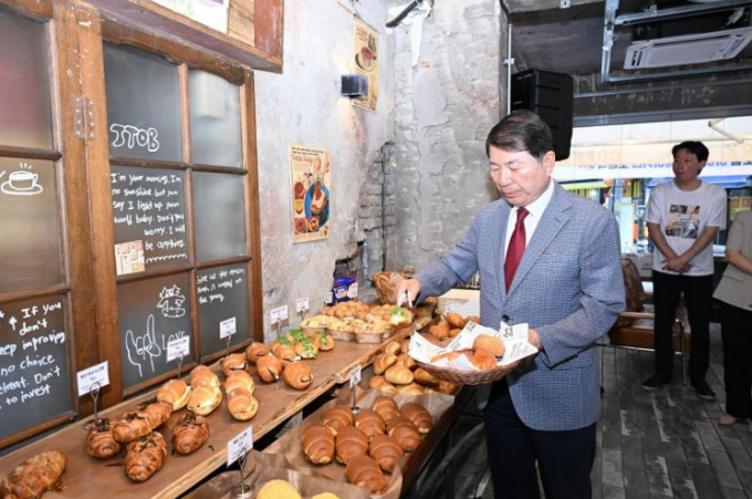 백경현 구리시상권활성화재단 이사장이 지난 10일 구리시 핵점포 육성을 위한 경영환경 개선사업으로 최대 지원금을 받은 '아이투비 베이커리'의 재단장 개점식을 마친 뒤 빵을 고르고 있다. /사진제공=구리시상권활성화재단