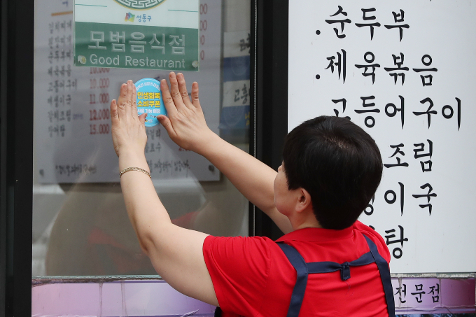 사진은 서울 성동구 한 가게에서 '민생회복 소비쿠폰 사용 가능 매장' 스티커를 부착하고 있는 모습. /사진=뉴스1