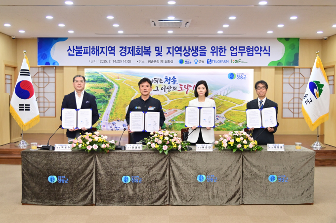 윤경희 청송군수(왼쪽에서 두번째)와 각 기관 관계자들이 산불피해지역 경제회복 및 지역 상생을 위한 업무협약식에서 협약서를 들어보이고 있다./사진제공=경북 청송군