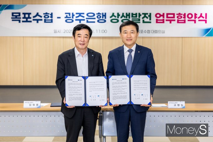 고병일 광주은행장(오른쪽)과 김청룡 목포수협 조합장이 상생발전을 위한 업무협약을 체결하고 있다/사진=광주은행 제공.