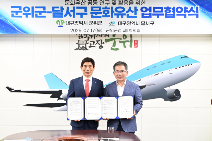 김진열 군위군수(오른쪽)와 이태훈 달서구청장(왼쪽)이 업무협약서를 들어보이고 있다./사진제공=대구 군위군