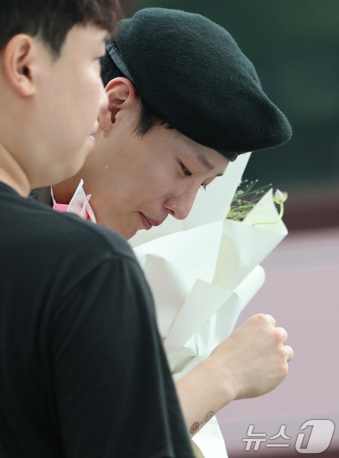 가수 우즈(WOODZ, 본명 조승연)가 21일 오전 서울 노원구 육군사관학교에서 전역식을 마친 뒤 환호하는 팬을 뒤로하고 눈시울을 닦고 있다.  ⓒ News1 권현진 기자