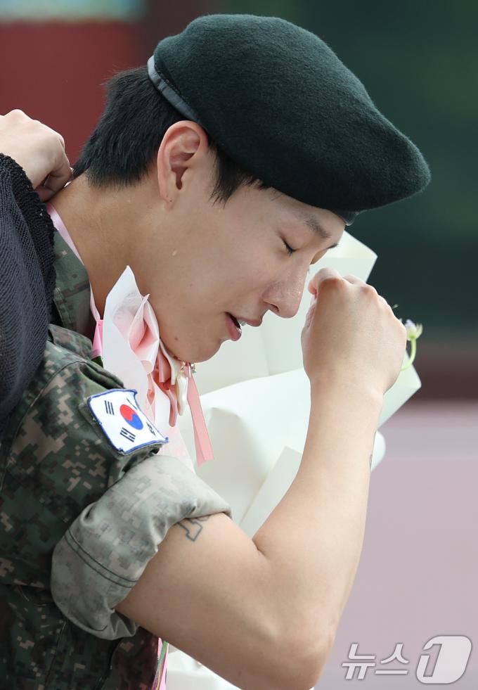 가수 우즈(WOODZ, 본명 조승연)가 21일 오전 서울 노원구 육군사관학교에서 전역식을 마친 뒤 환호하는 팬을 뒤로하고 붉어진 눈시울을 닦고 있다. ⓒ News1 권현진 기자