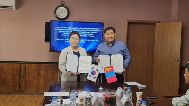 전미애 연천군탄소중립지원센터 센터장이 몽골 도르노드 도 초이발산시와 '국제 탄소중립사업을 위한 업무협약'을 21일 체결하고 협약서를 보이며 사진촬영을 하고 있다. /사진제공=연천군