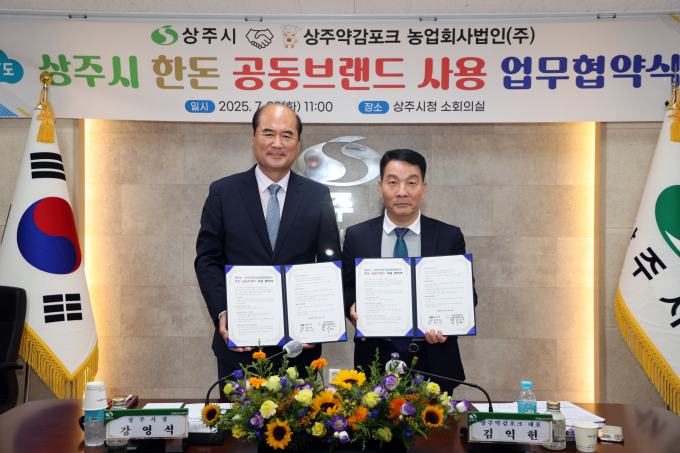 강영석 상주시장(왼쪽)과 김익현 상주약감포크 대표(오른쪽)가 업무협약서를 들어보이고 있다./사진제공=경북 상주시