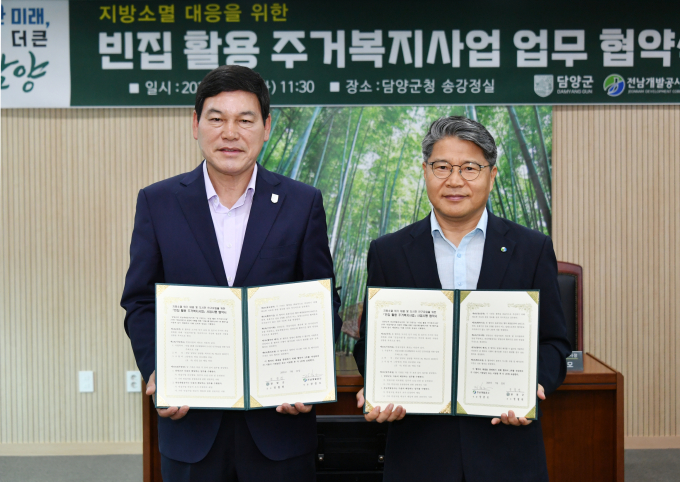 장충모 전남개발공사 사장(오른쪽)과 정철원 담양군수가 22일 담양군청에서 빈집활용  주거복지사업 시행을 위한 협약 체결후 기념 사진을 찍고 있다./전남개발공사
