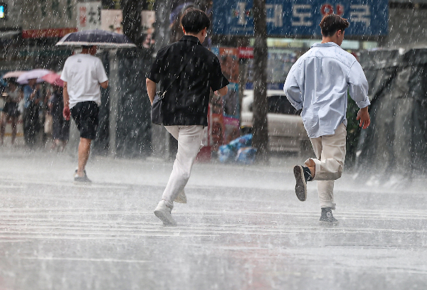 23일 낮 최고기온이 35도까지 오르는 등 무더위가 이어지겠다. 사진은 서울 종로구 종각역 인근에서 우산을 쓴 시민들이 발걸음을 재촉하는 모습. /사진=뉴스1