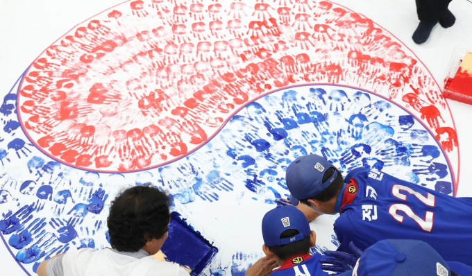 제80주년 광복절을 한 달 앞둔 지난달 15일 경기 수원시 권선구청에서 구청 공무원 및 보훈단체 관계자, 권선구 리틀야구단 선수 등 참가자들이 손도장을 찍어 태극기를 만들고 있는 모습. /사진=뉴스1