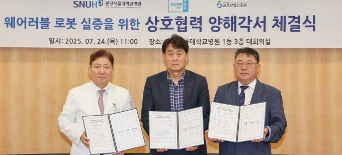 하은호 군포시장(가운데)이 지난 24일 원장 송정한 분당서울대학교병원 원장(왼쪽), 유병직 군포산업진흥원 원장(오른쪽)과 웨어러블 로봇 기술의 실증과 의료 현장 적용 확대를 위한 3자 업무협약을 체결하고 기념사진을 찍고 있다./사진제공=군포시 