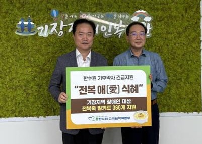 심준섭 고리원자력본부 지역협력부장(왼쪽)이 김영관 기장장애인복지관장에게 특식을 지원하고 기념 촬영을 하고 있다./사진=고리본부