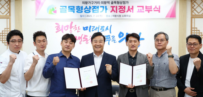 김성제 의왕시장(가운데)이 지난 24일 시청에서 신규 지정된 골목형상점가 상인회장과  상인대표단에게 지정서를 교부하고 포즈를 취하고 있다./사진제공=의왕시