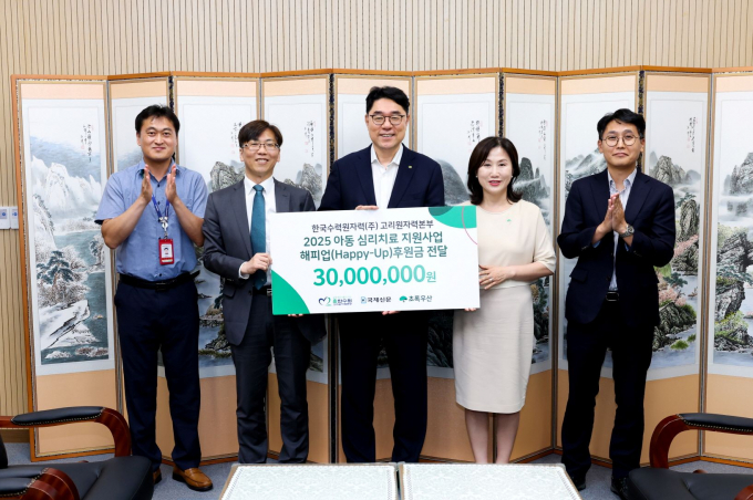 이상욱 고리원자력본부장(가운데)이 이수경 초록우산 어린이재단 부산지역본부장(왼쪽 네 번째)에게 후원금을 전달하고 관계자들과 기념 촬영을 하고 있다./사지고리본부