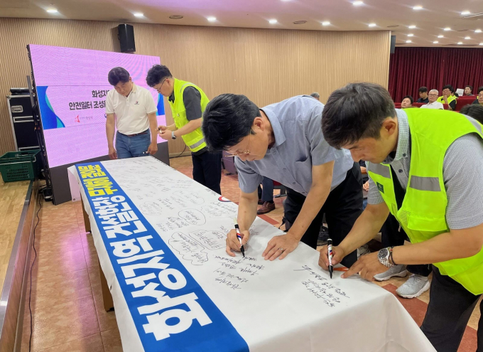 화성특례시 관내 공사현장 관계자 및 안전관리자들이 30일 무재해 결의대회에서 무재해 결의문 현수막에 안전기원 문구를 적고 있다. /사진제공=화성특례시