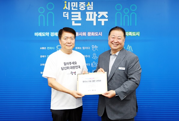 김경인 파주시장(오른쪽)이 지난달 31일  3층 대회의실에서 대통령 직속 국정기획위원회와 '버스로 찾아가는 모두의 광장' 행사를 열고 지역 현안 11개를 담아 건의서를 전달하고 있다. /사진제공=파주시